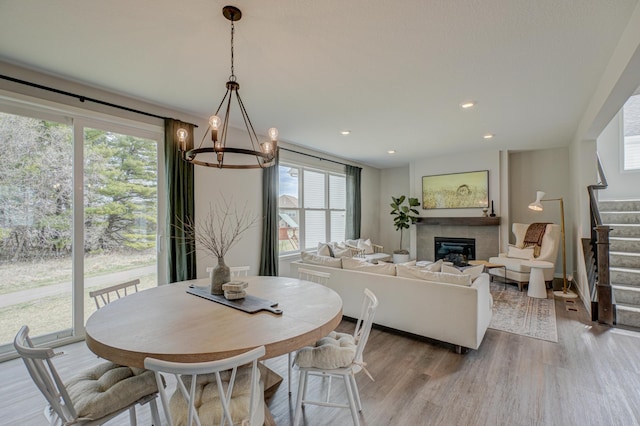 11422 34th St N, Lake Elmo, MN 55042 - dining room with stairway, healthy amount of natural light, wood finished floors, a glass covered fireplace, and recessed lighting