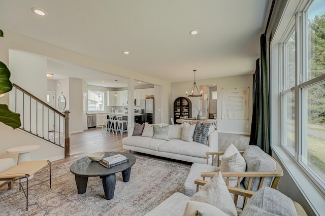 11422 34th St N, Lake Elmo, MN 55042 - living room with stairs, light wood finished floors, recessed lighting, baseboards, and a chandelier
