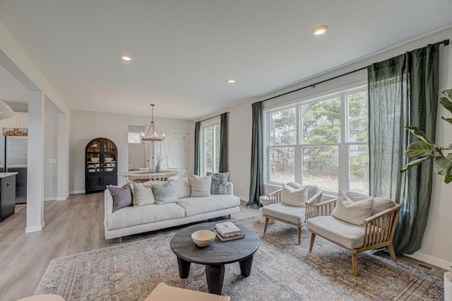 11422 34th St N, Lake Elmo, MN 55042 - living room featuring baseboards, light wood-style floors, recessed lighting, and a chandelier