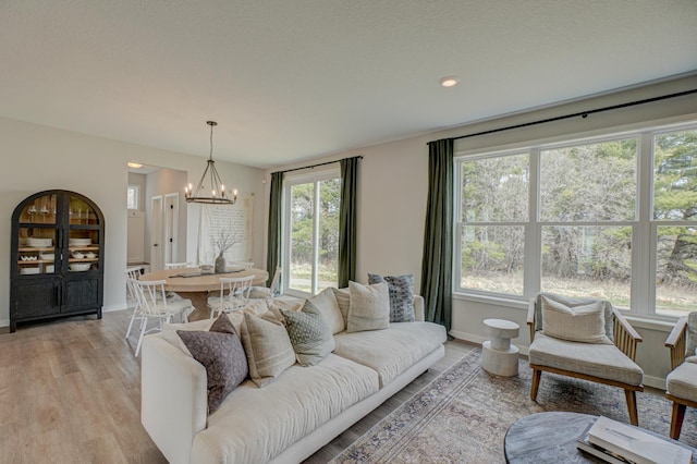 11422 34th St N, Lake Elmo, MN 55042 - living room featuring a chandelier, light wood-style flooring, and baseboards