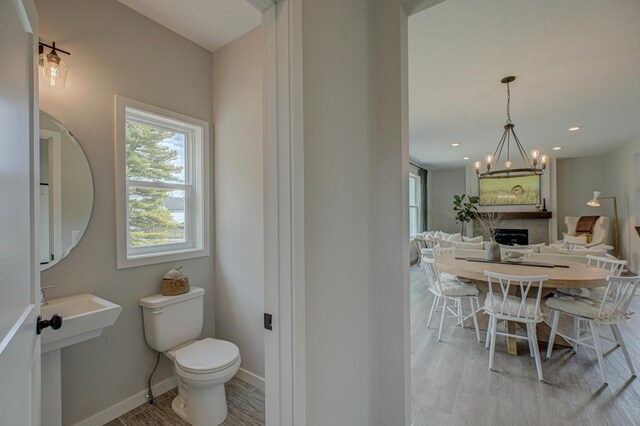 11422 34th St N, Lake Elmo, MN 55042 - bathroom featuring plenty of natural light, toilet, a chandelier, and wood finished floors