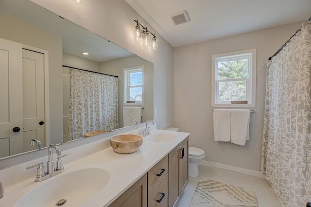 11422 34th St N, Lake Elmo, MN 55042 - full bathroom featuring plenty of natural light, toilet, double vanity, and baseboards