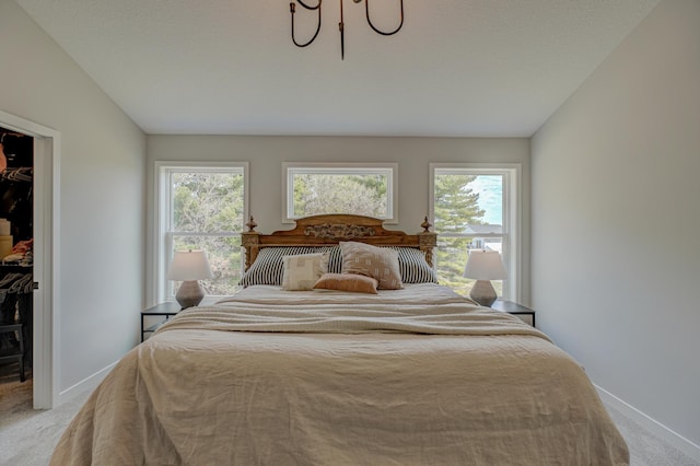 11422 34th St N, Lake Elmo, MN 55042 - bedroom with light carpet, a walk in closet, multiple windows, and vaulted ceiling