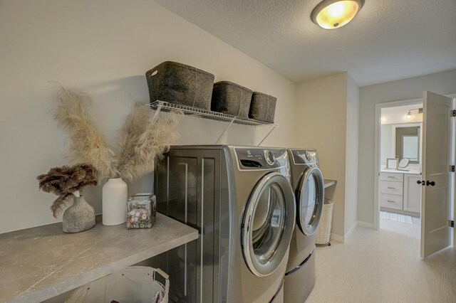 11422 34th St N, Lake Elmo, MN 55042 - laundry area with independent washer and dryer, a textured ceiling, and baseboards