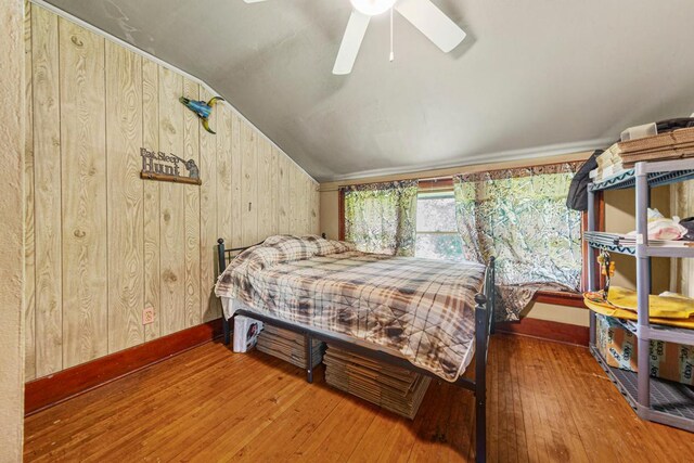 32673 Rosewood Ln, Saint Peter, MN 56082 - bedroom featuring lofted ceiling, wood-type flooring, wood walls, baseboards, and a ceiling fan