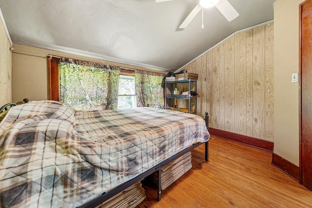 32673 Rosewood Ln, Saint Peter, MN 56082 - bedroom with vaulted ceiling, wood finished floors, baseboards, wooden walls, and ceiling fan
