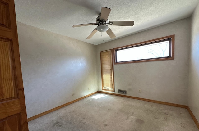 unfurnished room featuring light carpet, baseboards, a ceiling fan, and visible vents