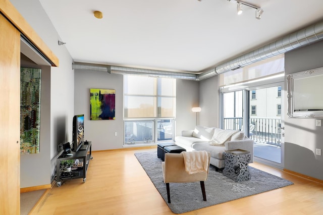 1211 Lagoon Ave Unit 308, Minneapolis, MN 55408 - living area featuring rail lighting, wood finished floors, and baseboards