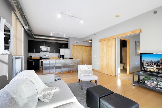 1211 Lagoon Ave Unit 308, Minneapolis, MN 55408 - living area featuring rail lighting, visible vents, and light wood-style flooring