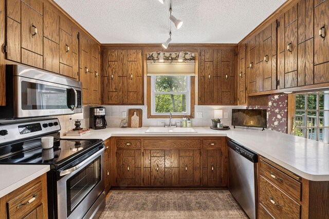 14704 Glendale Ave SE, Prior Lake, MN 55372 - kitchen featuring stainless steel appliances, a sink, a peninsula, light countertops, and decorative backsplash