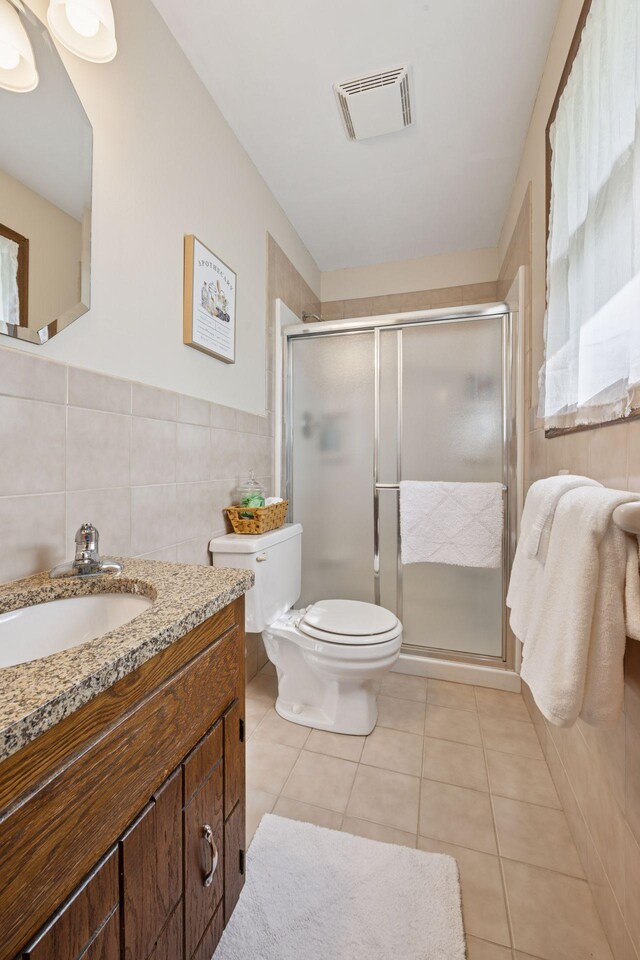 14704 Glendale Ave SE, Prior Lake, MN 55372 - bathroom featuring tile walls, vanity, toilet, a shower stall, and tile patterned flooring