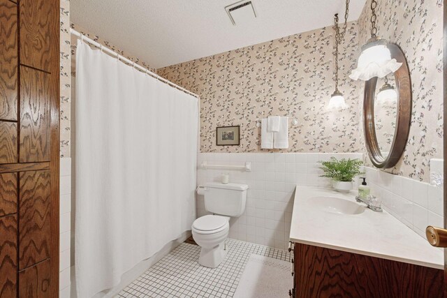 14704 Glendale Ave SE, Prior Lake, MN 55372 - bathroom featuring wallpapered walls, vanity, toilet, wainscoting, and tile patterned flooring