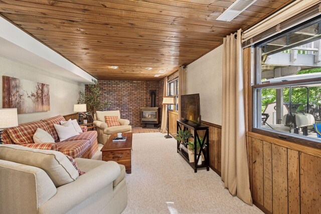 14704 Glendale Ave SE, Prior Lake, MN 55372 - carpeted living room featuring a wood stove, wooden ceiling, wood walls, and a wainscoted wall