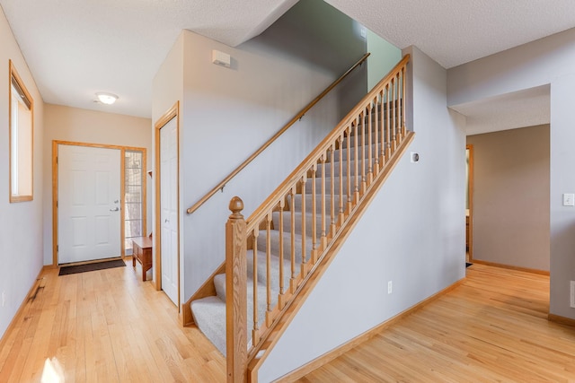 entrance foyer featuring stairs, baseboards, and hardwood / wood-style flooring