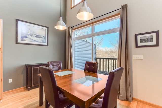 dining space featuring light wood finished floors and baseboards