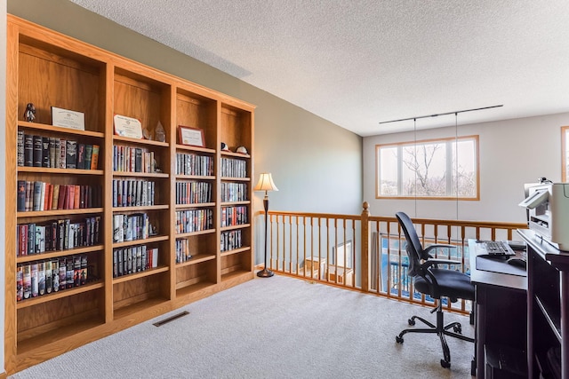 office area with a textured ceiling, carpet, and visible vents