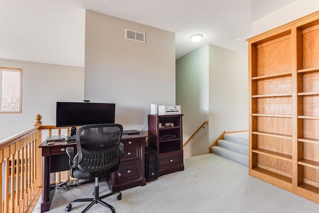 office space featuring a textured ceiling, visible vents, and carpet floors