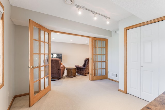 sitting room with french doors, rail lighting, carpet flooring, and visible vents