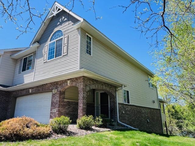 587 Crane Creek Ln, Eagan, MN 55121 - view of property exterior featuring brick siding, an attached garage, and a lawn