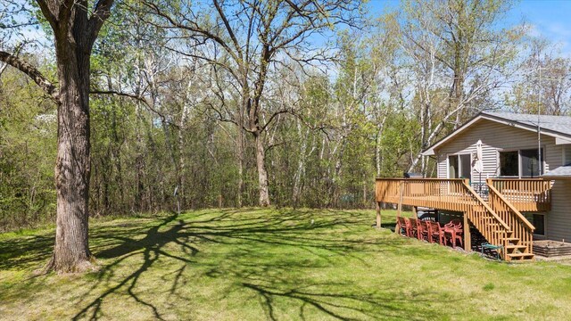 view of grassy yard with a deck and stairway