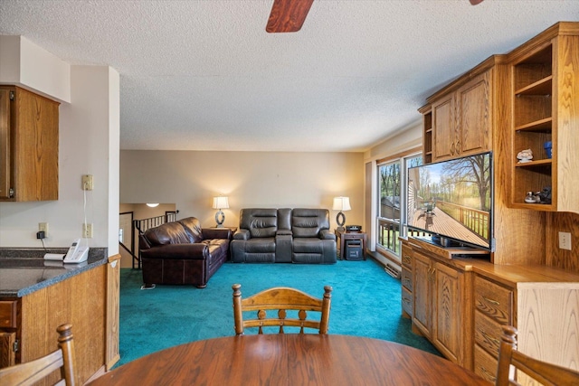 living room featuring dark colored carpet, a textured ceiling, and ceiling fan