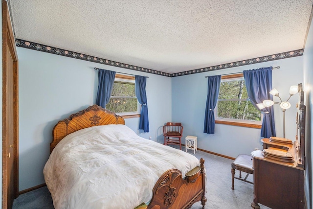carpeted bedroom with multiple windows, a textured ceiling, and baseboards