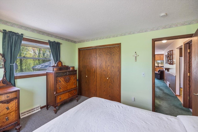 bedroom featuring carpet, a closet, a textured ceiling, and baseboards