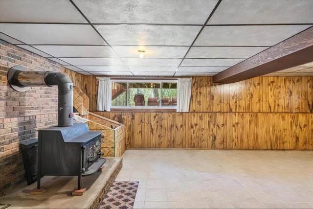 below grade area featuring a wood stove and wooden walls