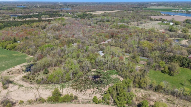 view of property location with a nearby body of water and a forest