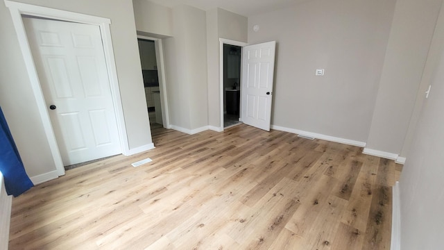 1023 17th Ave SE, Minneapolis, MN 55414 - unfurnished bedroom featuring light wood-type flooring and baseboards