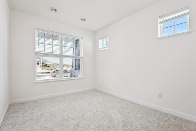 carpeted spare room featuring baseboards