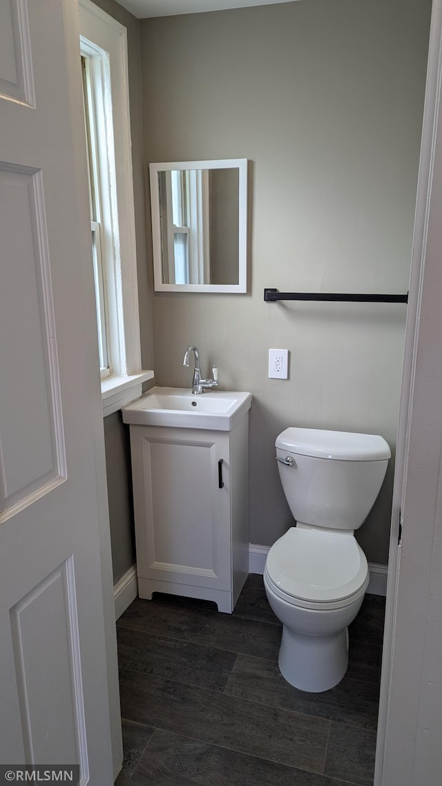 3454 Newton Ave N, Minneapolis, MN 55412 - half bath featuring vanity, baseboards, wood finished floors, and toilet