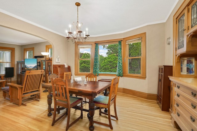 1757 Minnehaha Ave W, Saint Paul, MN 55104 - dining space with light wood-style flooring, arched walkways, a chandelier, baseboards, and crown molding