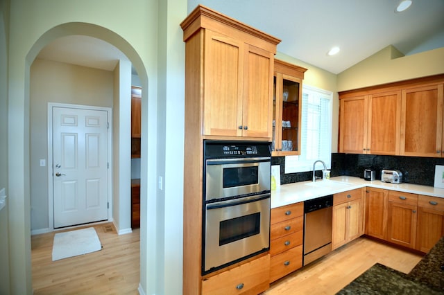 13258 Derryglenn Ct, Rosemount, MN 55068 - kitchen with appliances with stainless steel finishes, light wood-style flooring, tasteful backsplash, arched walkways, and a sink
