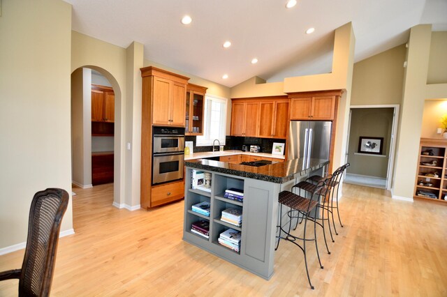 13258 Derryglenn Ct, Rosemount, MN 55068 - kitchen with stainless steel appliances, a breakfast bar area, a sink, a kitchen island, and light wood-style floors