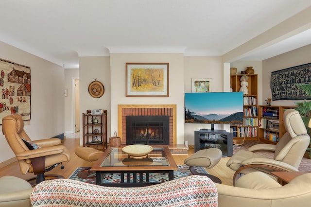 living room with a brick fireplace and wood finished floors
