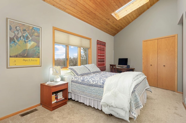 carpeted bedroom featuring baseboards, visible vents, vaulted ceiling with skylight, a closet, and wood ceiling