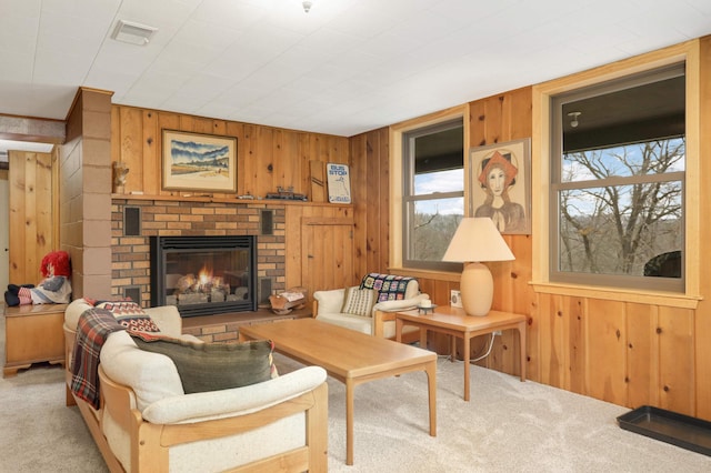 carpeted living area featuring a fireplace, visible vents, and wood walls