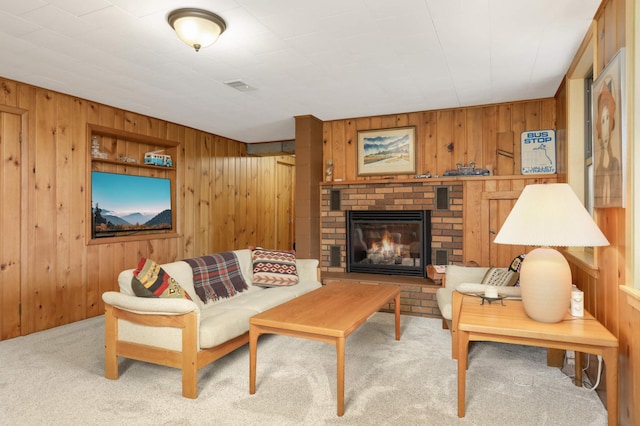 living room with wood walls, carpet flooring, visible vents, and a fireplace