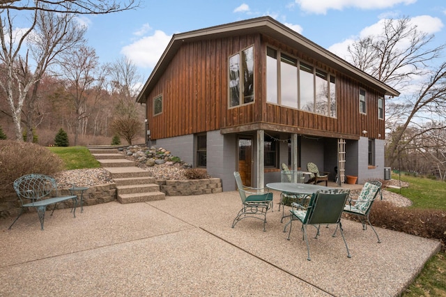 back of property featuring a patio area and outdoor dining area