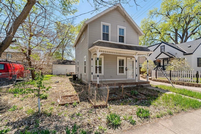 view of front of home with covered porch, fence, and central AC