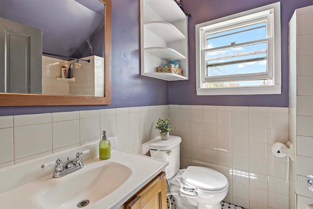 full bath featuring tile walls, toilet, vanity, and a shower