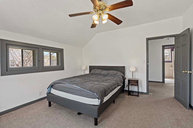 bedroom featuring carpet, baseboards, a textured ceiling, vaulted ceiling, and a ceiling fan