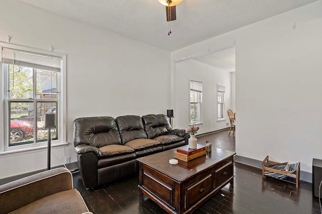 living room with dark wood-style flooring and a ceiling fan