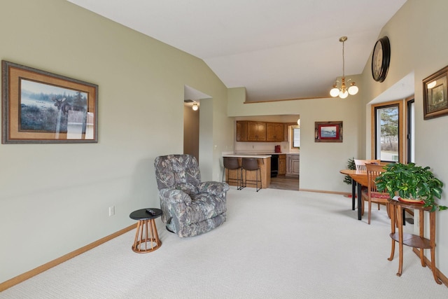 sitting room with vaulted ceiling, baseboards, and light carpet