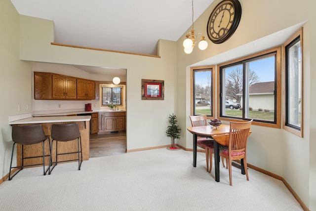 dining space with light carpet and baseboards
