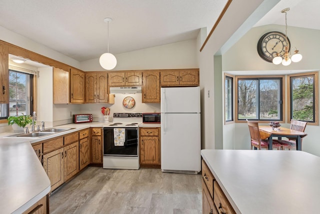 kitchen with under cabinet range hood, vaulted ceiling, a sink, white appliances, and a chandelier