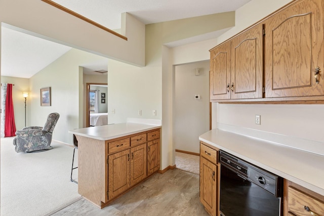 kitchen with light countertops, baseboards, a peninsula, black dishwasher, and a kitchen bar