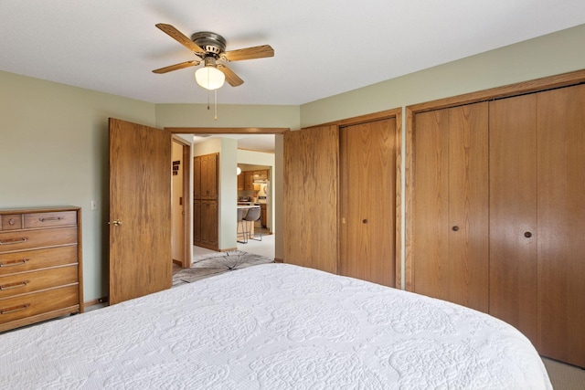 carpeted bedroom featuring a ceiling fan and multiple closets