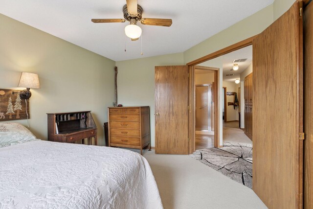 bedroom featuring visible vents, a ceiling fan, and light carpet